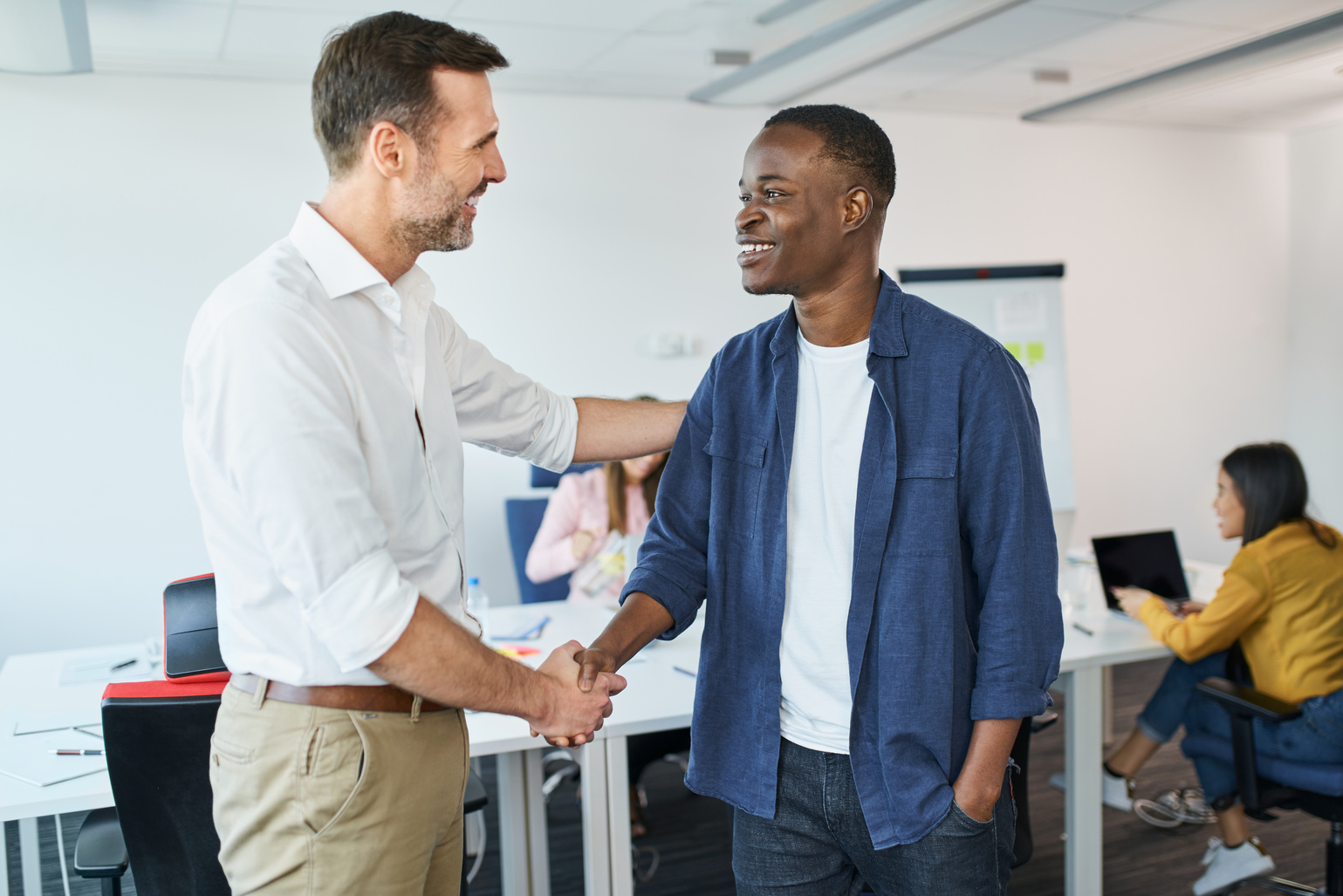 Business onboarding concept. Manager welcomes new employee in startup business office.